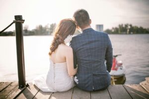 Bride and groom sitting on dock