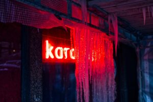 a red neon sign hanging from the side of a building