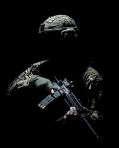 man in black and green camouflage suit holding rifle