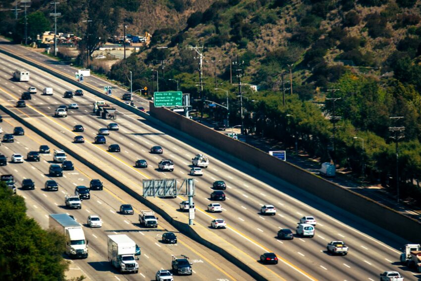 Cars are traveling along a busy multi-lane highway.